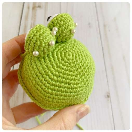 Original crochet frog tutorial photo 33, showing the eyes being assembled and sewn onto the frog.